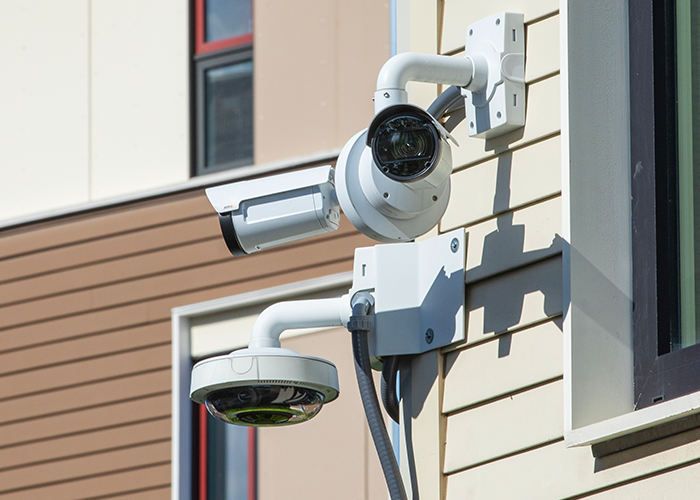 Security cameras posted on the exterior of housing complex.